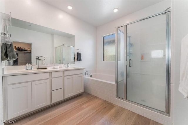 bathroom with plus walk in shower, wood-type flooring, and vanity