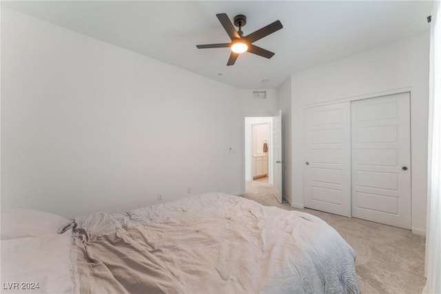 bedroom featuring ceiling fan, light colored carpet, and a closet