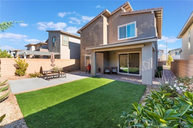rear view of house with a yard and a patio area
