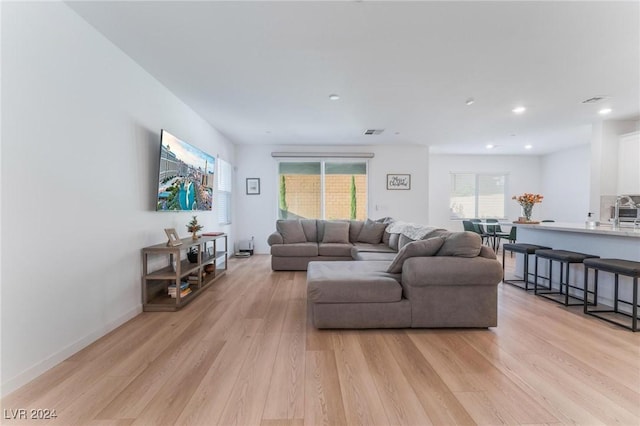 living room featuring sink and light hardwood / wood-style flooring