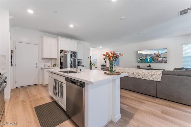 kitchen featuring white cabinetry, a kitchen island with sink, stainless steel appliances, and light wood-type flooring