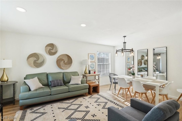 living room with a notable chandelier and light wood-type flooring