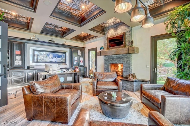 interior space with a fireplace, plenty of natural light, coffered ceiling, and light wood-type flooring