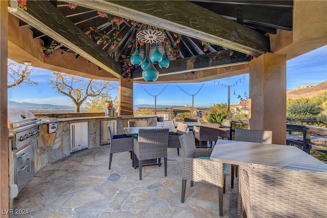 view of patio with a gazebo, area for grilling, a mountain view, and an outdoor kitchen