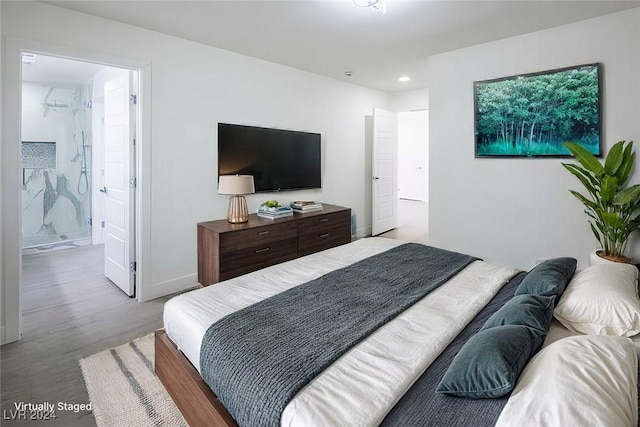 bedroom featuring light wood-type flooring and ensuite bath