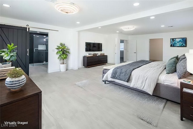 bedroom featuring a barn door and ensuite bathroom