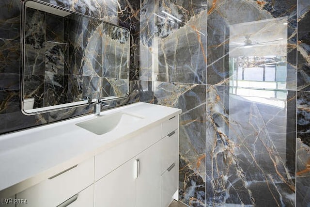 bathroom with vanity and tile walls