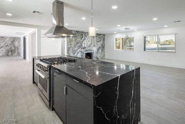 kitchen with high end stainless steel range oven, a premium fireplace, a spacious island, decorative light fixtures, and exhaust hood