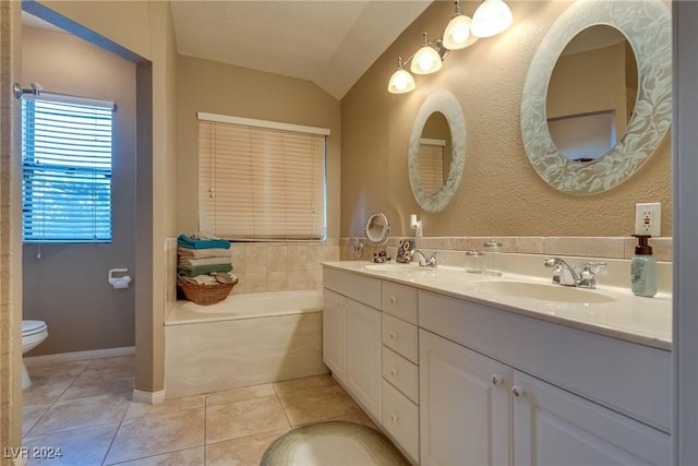 bathroom with a garden tub, double vanity, toilet, a sink, and tile patterned flooring