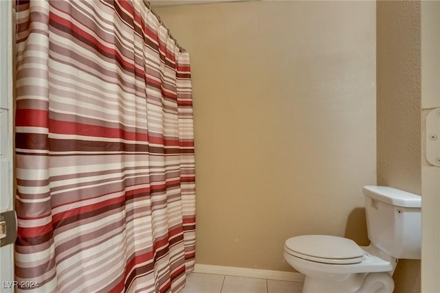 full bath with curtained shower, tile patterned flooring, toilet, and baseboards