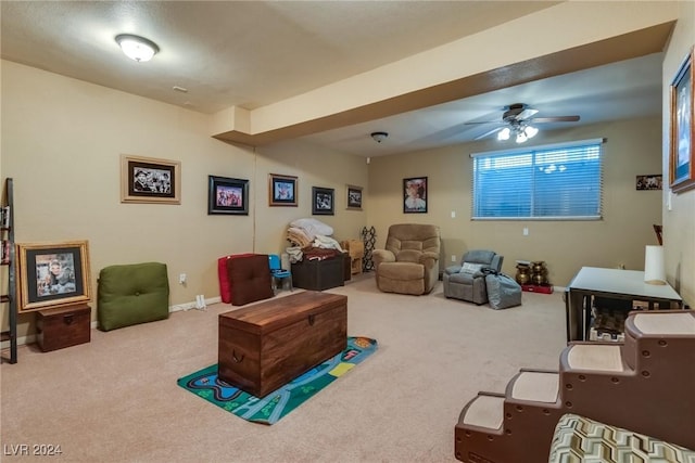 carpeted living room with a ceiling fan and baseboards