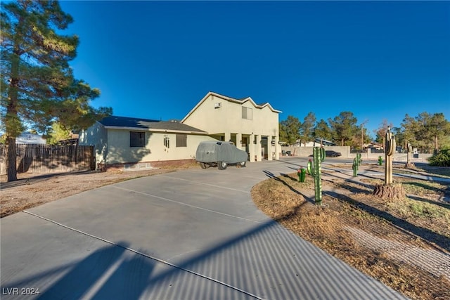 view of front of property with solar panels, fence, and stucco siding