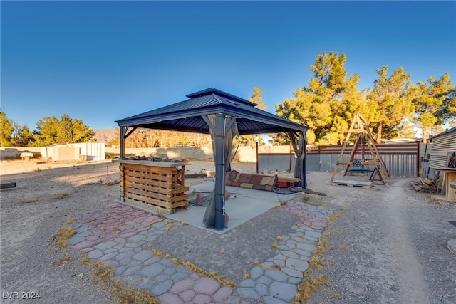 view of patio featuring a fenced backyard, a playground, and a gazebo