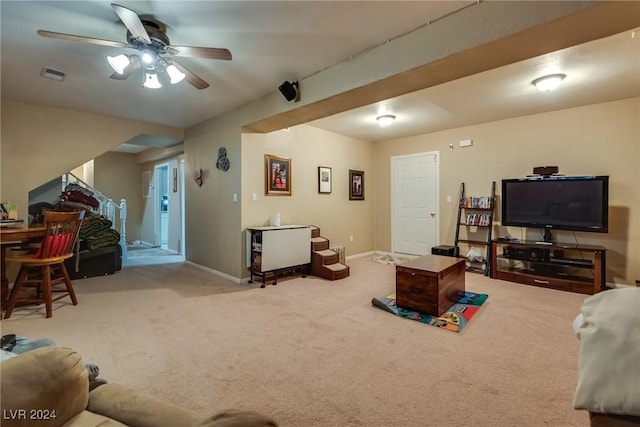 carpeted living room featuring baseboards, visible vents, and a ceiling fan