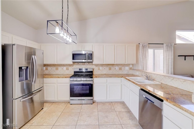 kitchen with sink, light tile patterned floors, pendant lighting, white cabinets, and appliances with stainless steel finishes