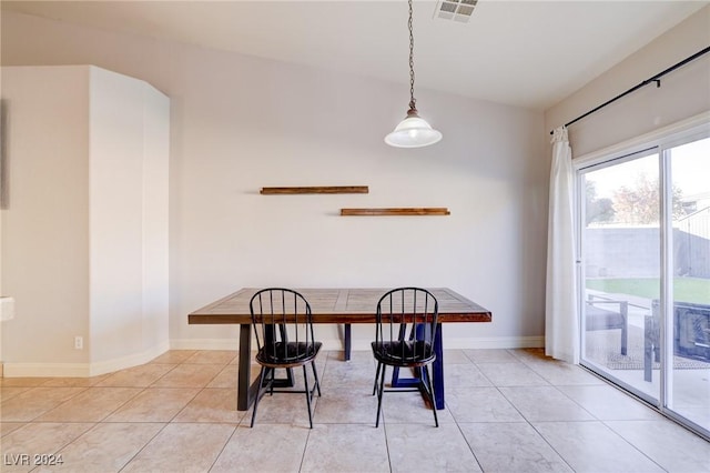 tiled dining space with lofted ceiling