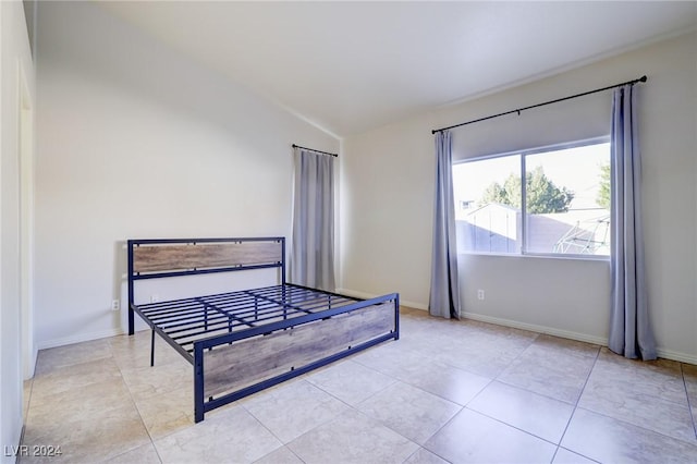 bedroom with lofted ceiling and light tile patterned flooring