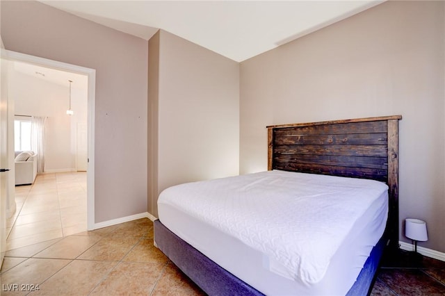 tiled bedroom featuring vaulted ceiling