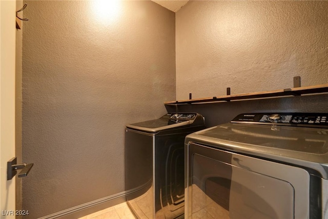 laundry room with washer and clothes dryer and light tile patterned flooring