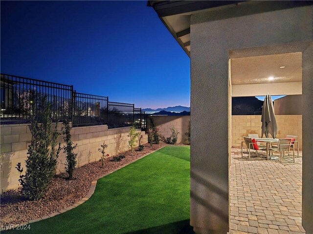 yard at dusk with a mountain view and a patio