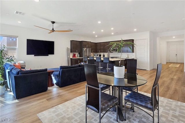 dining room with ceiling fan and light wood-type flooring