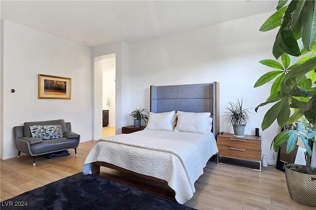 bedroom featuring ensuite bathroom and light hardwood / wood-style floors