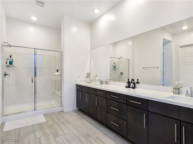 bathroom featuring walk in shower and vanity