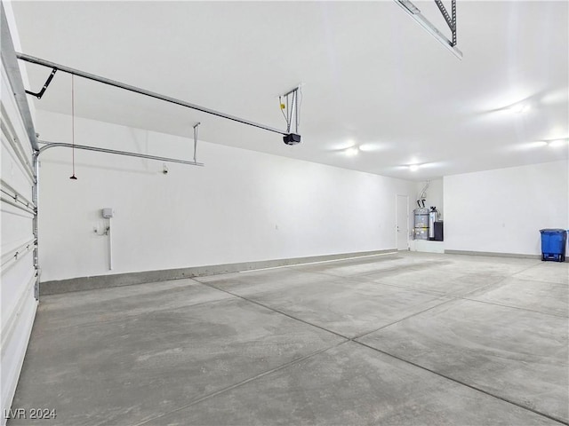 garage featuring strapped water heater and a garage door opener