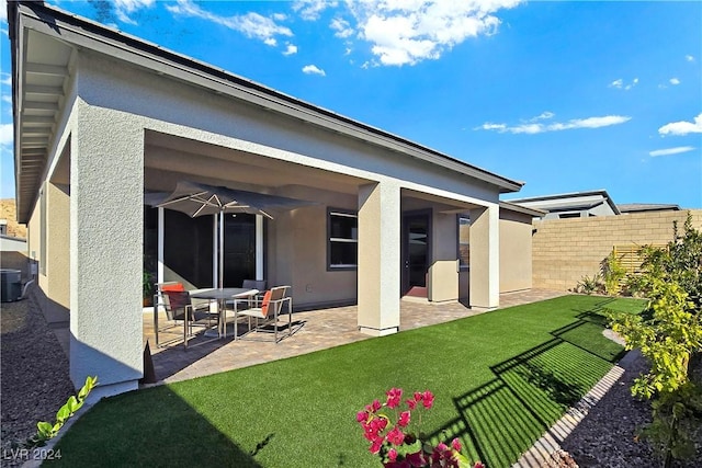 back of house with a yard and a patio