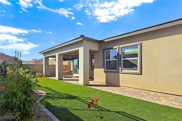 back of property featuring a patio area and a lawn