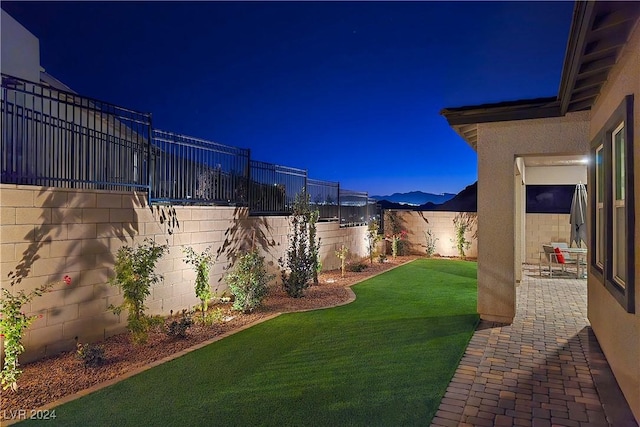 yard at twilight featuring a patio