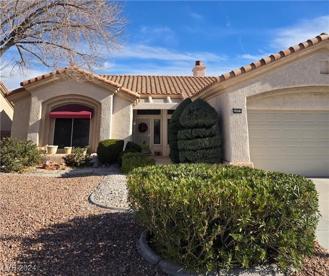 mediterranean / spanish-style home with a garage