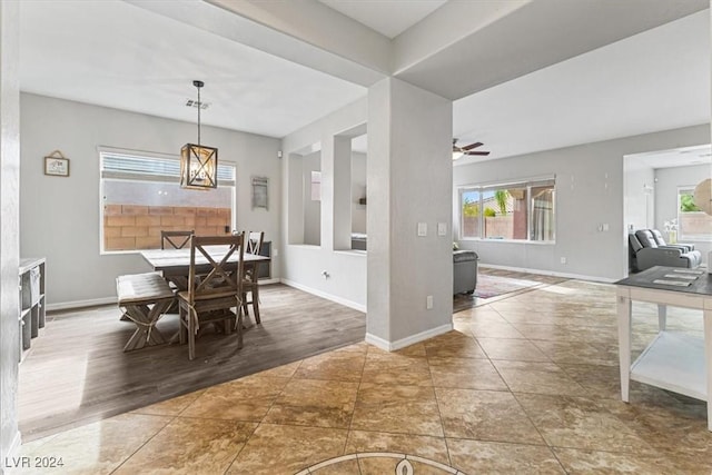 dining space with ceiling fan with notable chandelier and dark hardwood / wood-style floors