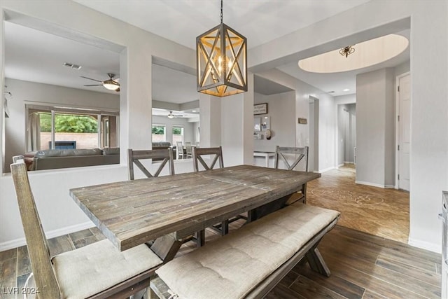 dining room with ceiling fan with notable chandelier and hardwood / wood-style flooring