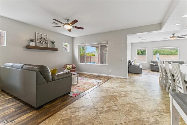 living room with ceiling fan, wood-type flooring, and a wealth of natural light