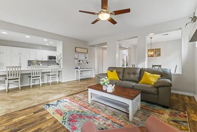 living room with ceiling fan and dark wood-type flooring