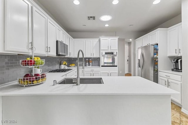 kitchen with kitchen peninsula, white cabinetry, sink, and appliances with stainless steel finishes