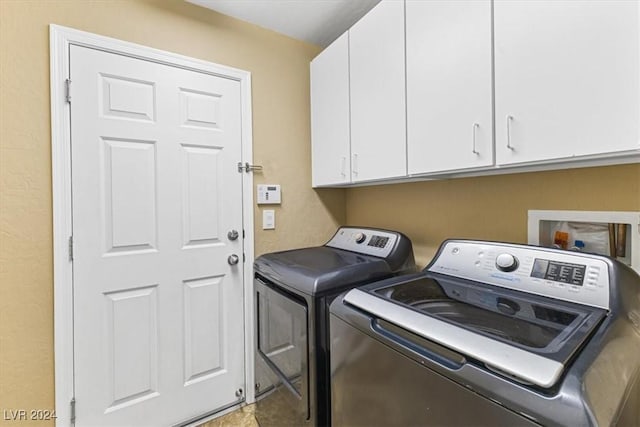 laundry room featuring cabinets and washing machine and clothes dryer