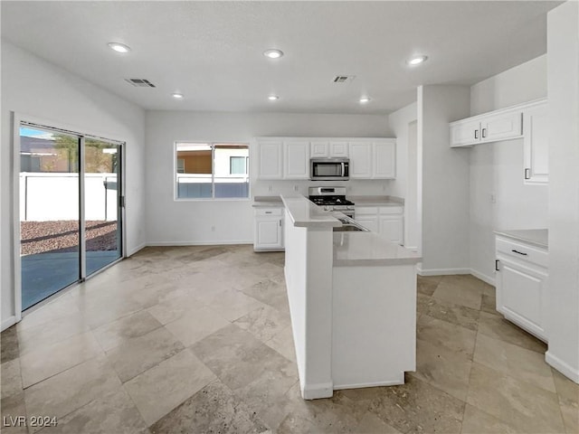 kitchen featuring a kitchen island, sink, white cabinetry, and stainless steel appliances