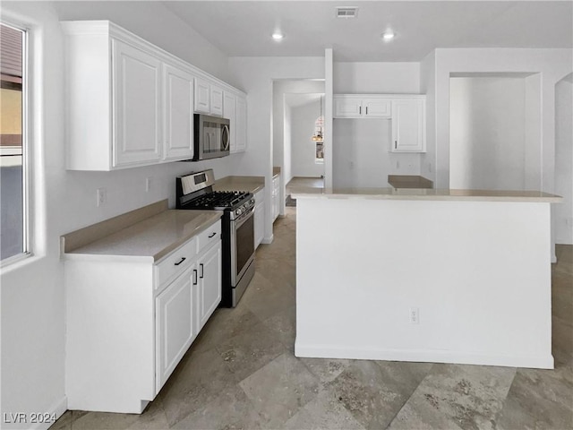 kitchen featuring white cabinets, a center island, and stainless steel appliances