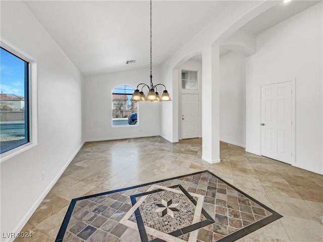 unfurnished dining area featuring a wealth of natural light, lofted ceiling, and a notable chandelier