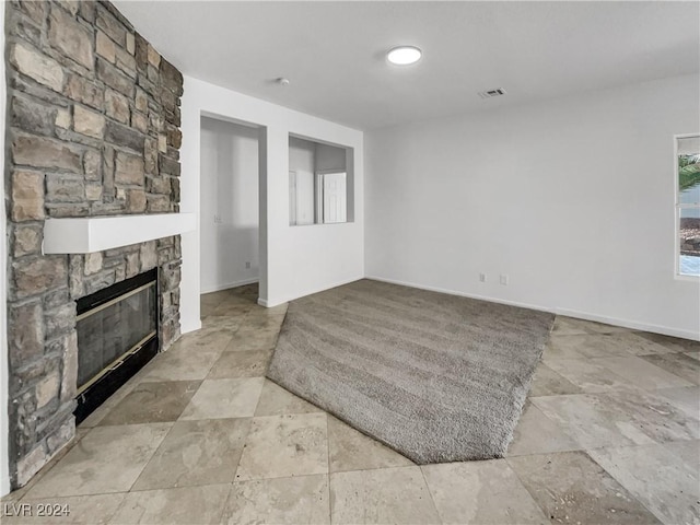 living room featuring a stone fireplace