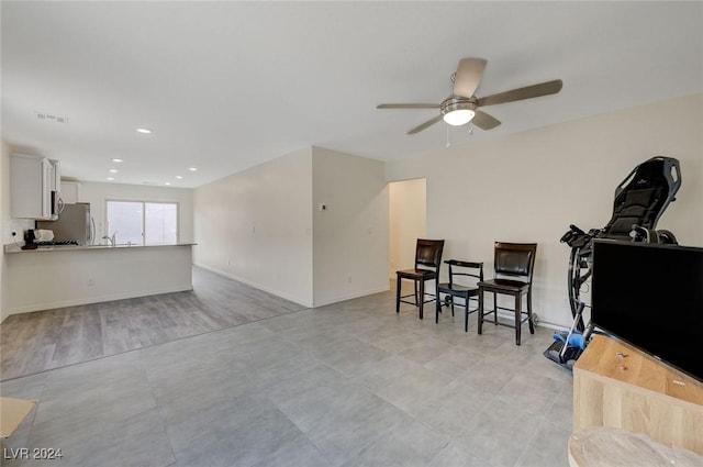 living room featuring ceiling fan and light wood-type flooring