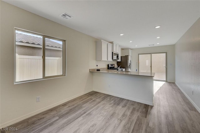 kitchen with white cabinets, plenty of natural light, and kitchen peninsula