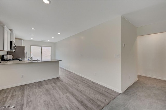 kitchen featuring sink, light wood-type flooring, white cabinetry, and stainless steel appliances