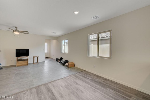 workout area featuring ceiling fan and light hardwood / wood-style flooring