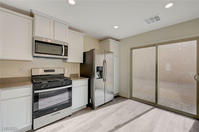 kitchen featuring white cabinets, light wood-type flooring, and stainless steel appliances