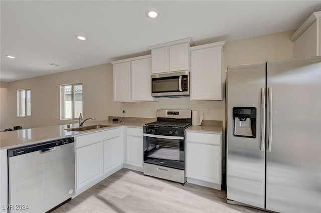 kitchen featuring kitchen peninsula, sink, stainless steel appliances, and light hardwood / wood-style floors