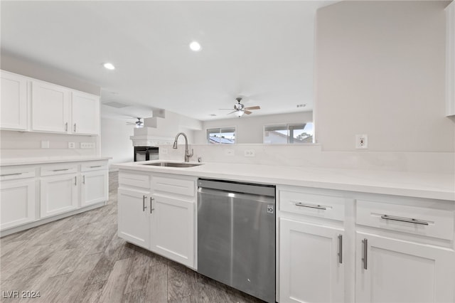 kitchen featuring white cabinets, sink, stainless steel dishwasher, ceiling fan, and light hardwood / wood-style floors