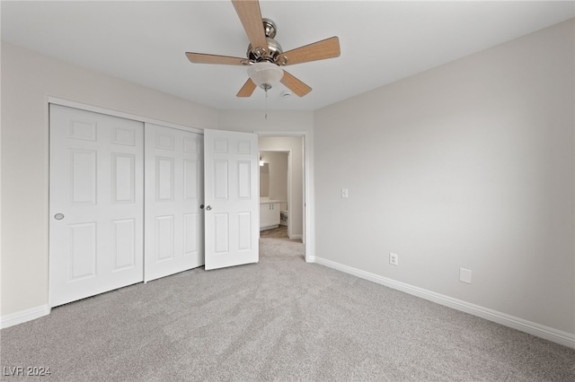 unfurnished bedroom with ceiling fan, light carpet, and a closet